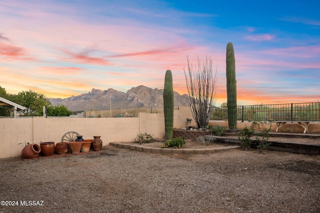 yard at dusk featuring a mountain view