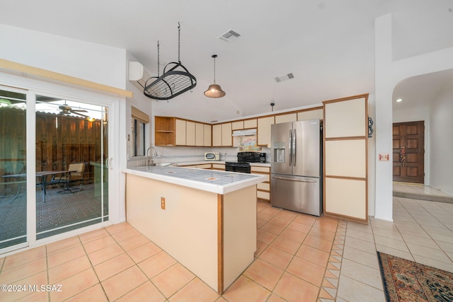 kitchen featuring kitchen peninsula, black stove, light tile patterned floors, decorative light fixtures, and stainless steel fridge with ice dispenser