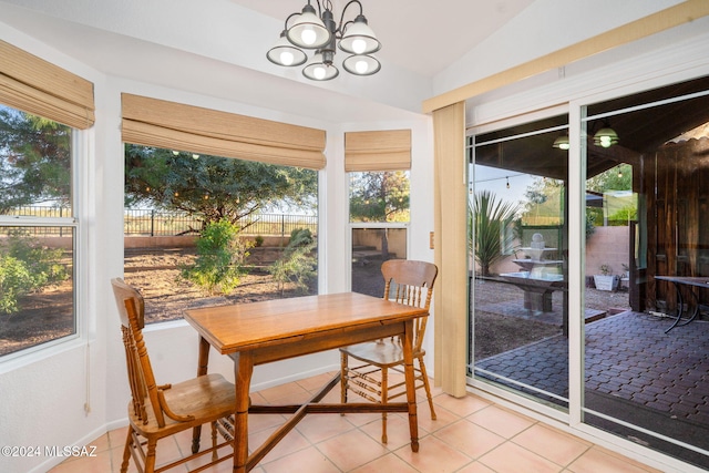 sunroom featuring an inviting chandelier and vaulted ceiling