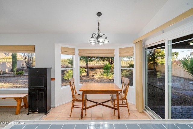 tiled dining room with an inviting chandelier, a wealth of natural light, and lofted ceiling