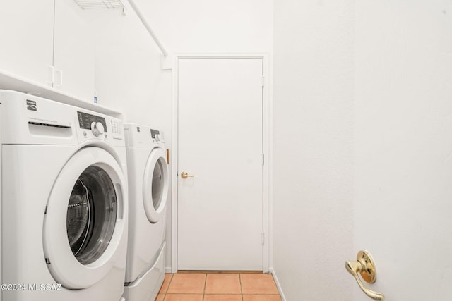 washroom featuring cabinets, independent washer and dryer, and light tile patterned floors