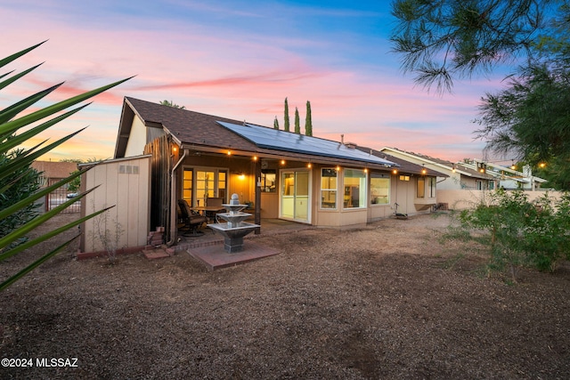 back house at dusk featuring solar panels