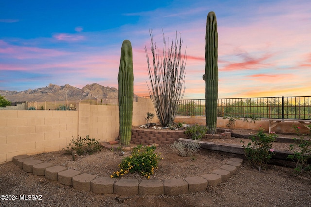 yard at dusk featuring a mountain view