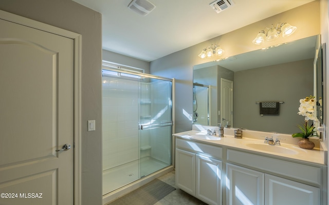 bathroom with tile patterned floors, vanity, and a shower with door