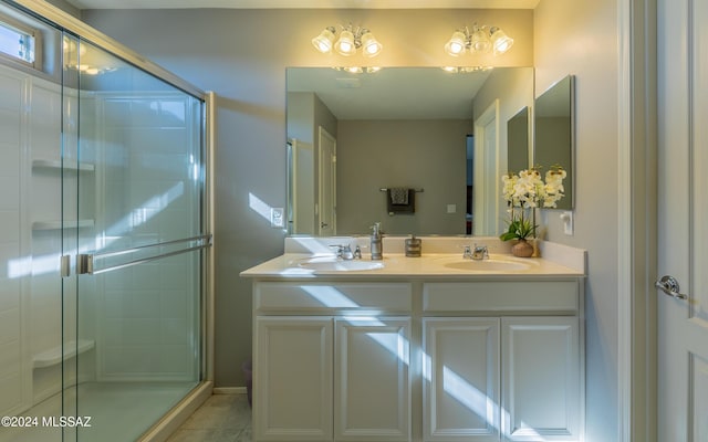 bathroom featuring tile patterned floors, vanity, and a shower with door