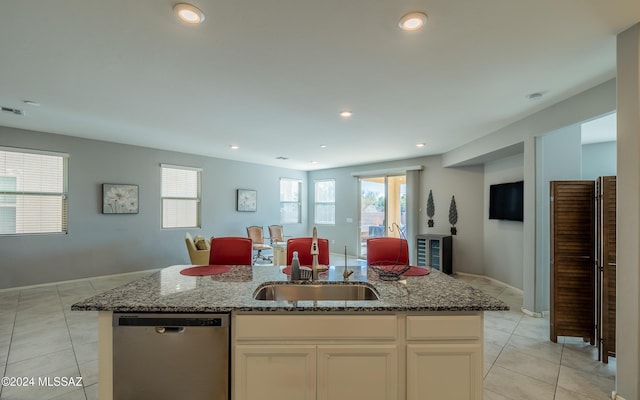 kitchen with dishwasher, a center island with sink, white cabinets, sink, and light stone counters