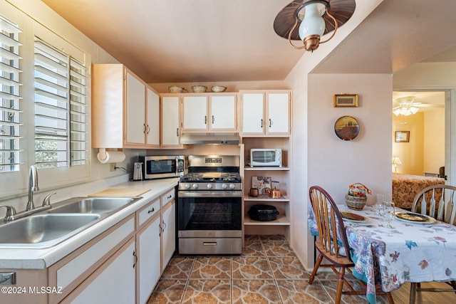 kitchen with white cabinetry, stainless steel appliances, kitchen peninsula, and sink