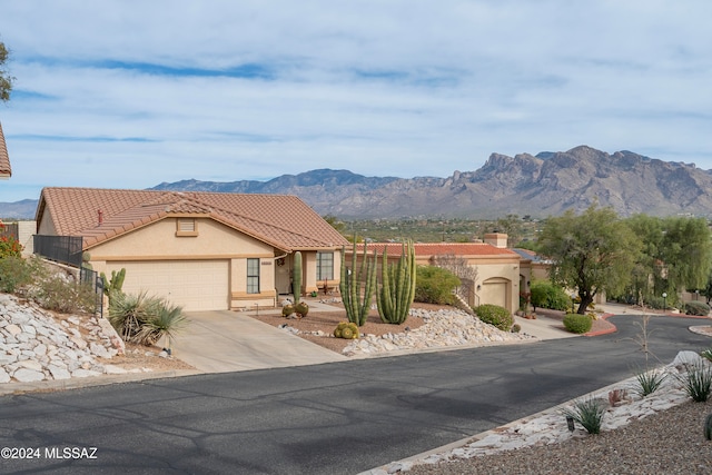 view of front of home with a mountain view and a garage