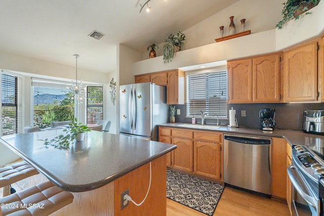 kitchen featuring a kitchen breakfast bar, stainless steel appliances, a wealth of natural light, and sink