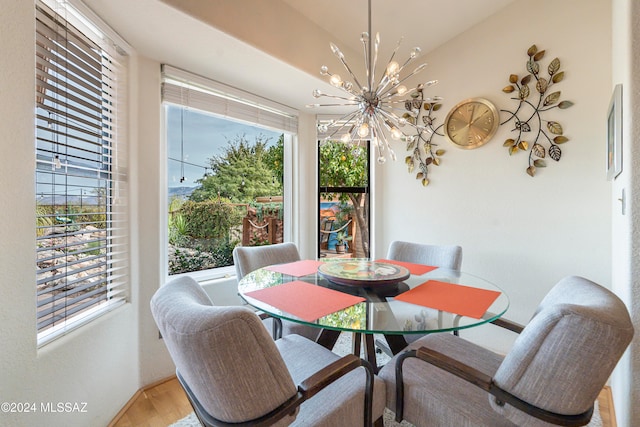 dining space with hardwood / wood-style flooring, an inviting chandelier, and a wealth of natural light