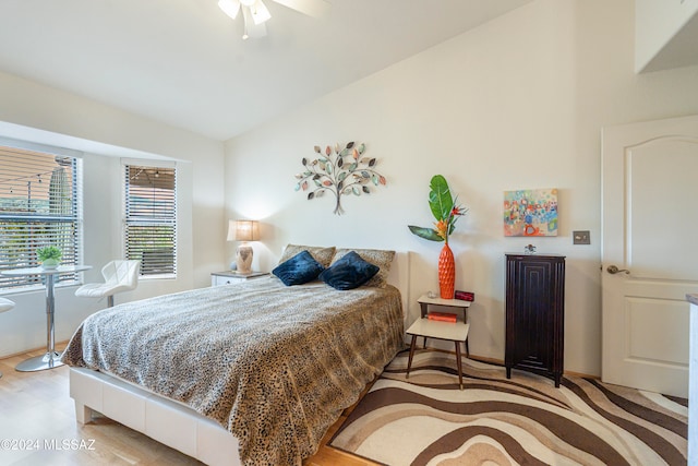 bedroom with ceiling fan, light wood-type flooring, and vaulted ceiling