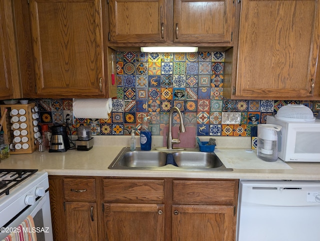 kitchen with white appliances, tasteful backsplash, and sink