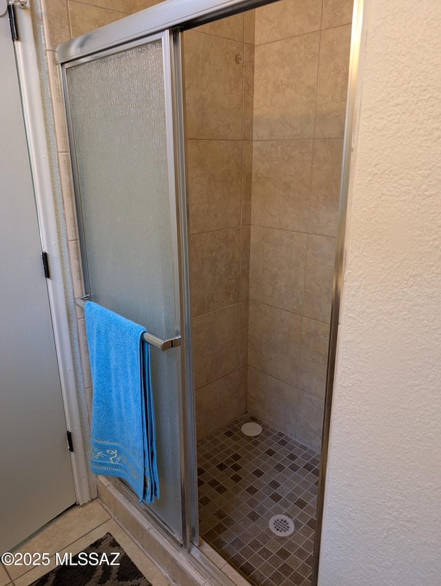 bathroom featuring tile patterned floors and a shower with shower door