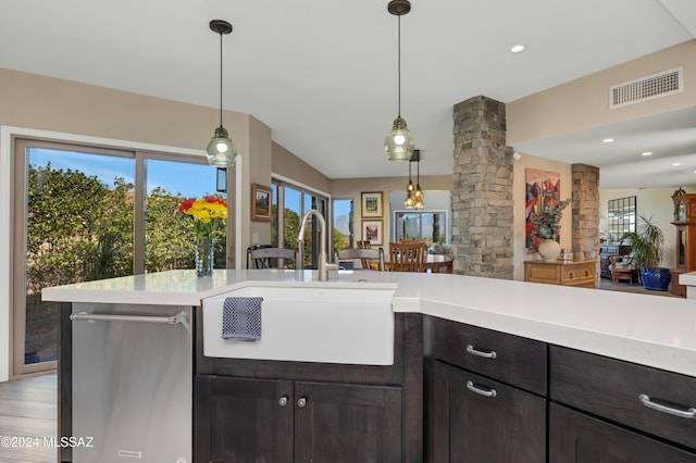 kitchen with a sink, visible vents, open floor plan, and light countertops