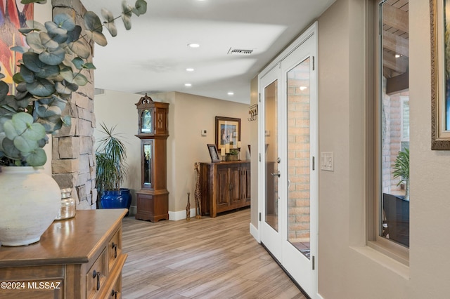 corridor featuring baseboards, recessed lighting, visible vents, and light wood-type flooring