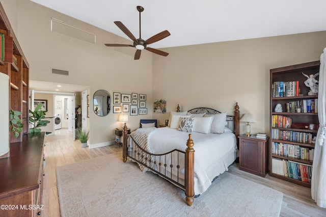 bedroom featuring washer / dryer, light wood-style floors, visible vents, and baseboards