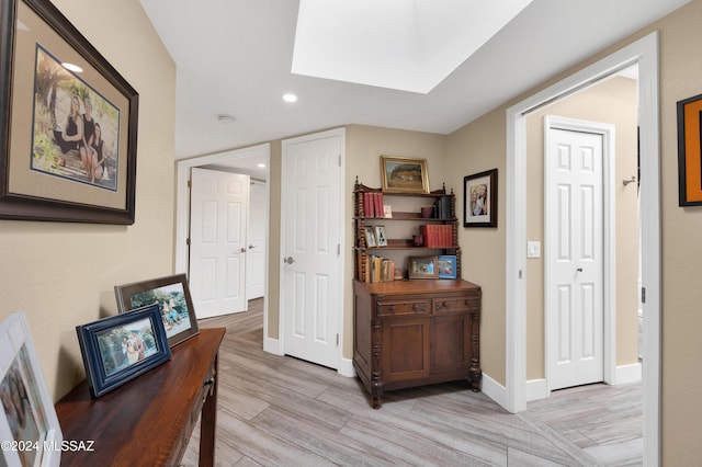 corridor featuring recessed lighting, baseboards, and light wood finished floors