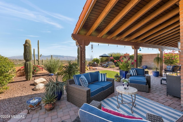 view of patio / terrace featuring fence, a mountain view, and an outdoor hangout area