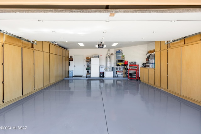 garage featuring gas water heater and freestanding refrigerator