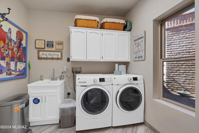 laundry room with a sink, cabinet space, and washing machine and dryer