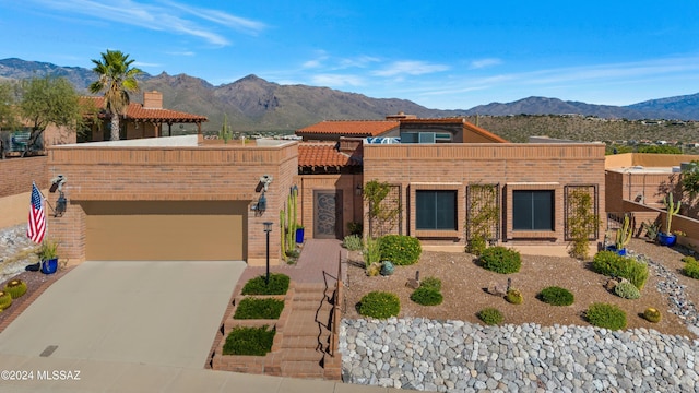 view of front of property with brick siding, a mountain view, concrete driveway, and an attached garage