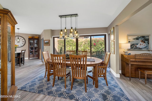 dining room featuring a notable chandelier, baseboards, and wood finished floors