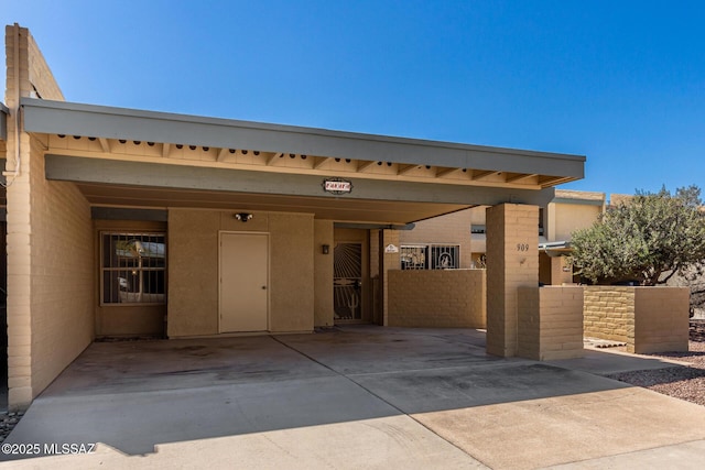 pueblo-style house featuring a carport and driveway