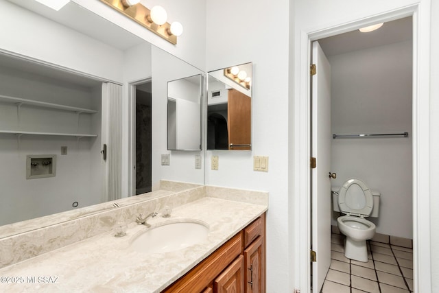 bathroom featuring toilet, vanity, and tile patterned floors