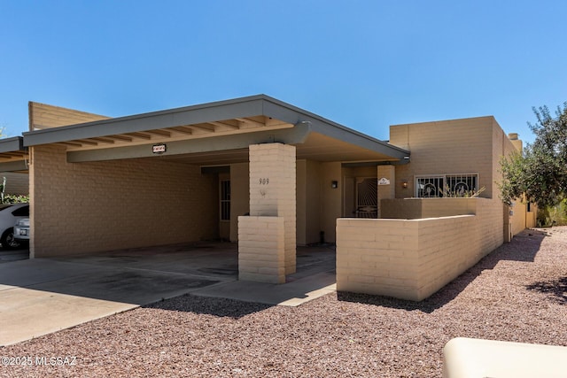 view of front of property featuring a carport and concrete driveway