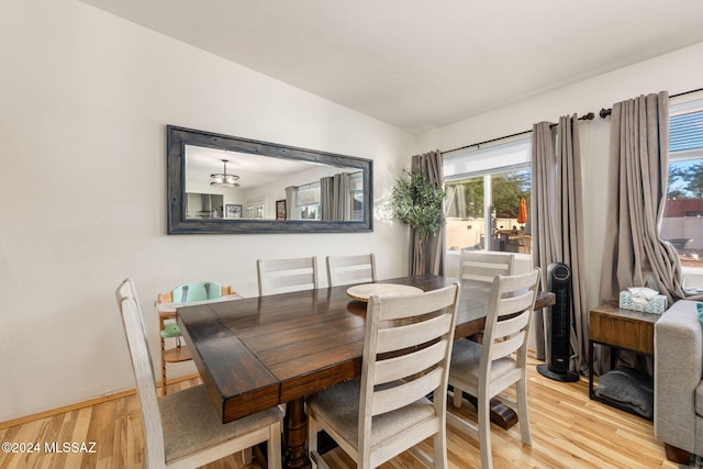 dining room with light wood-type flooring and lofted ceiling