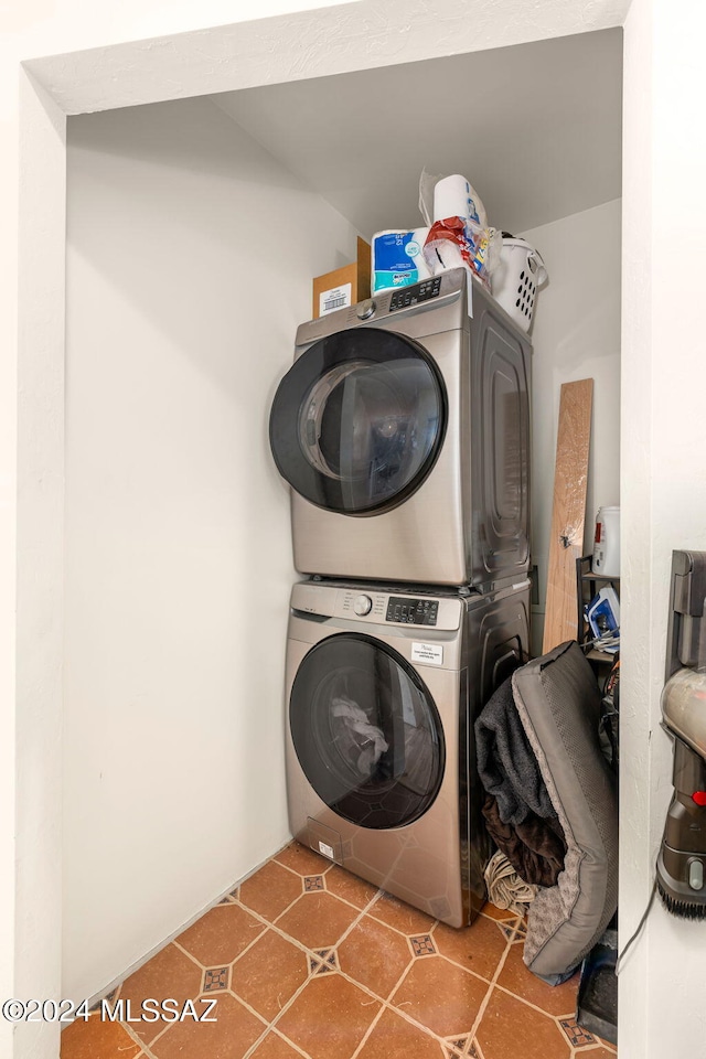 clothes washing area featuring tile patterned flooring and stacked washer / drying machine