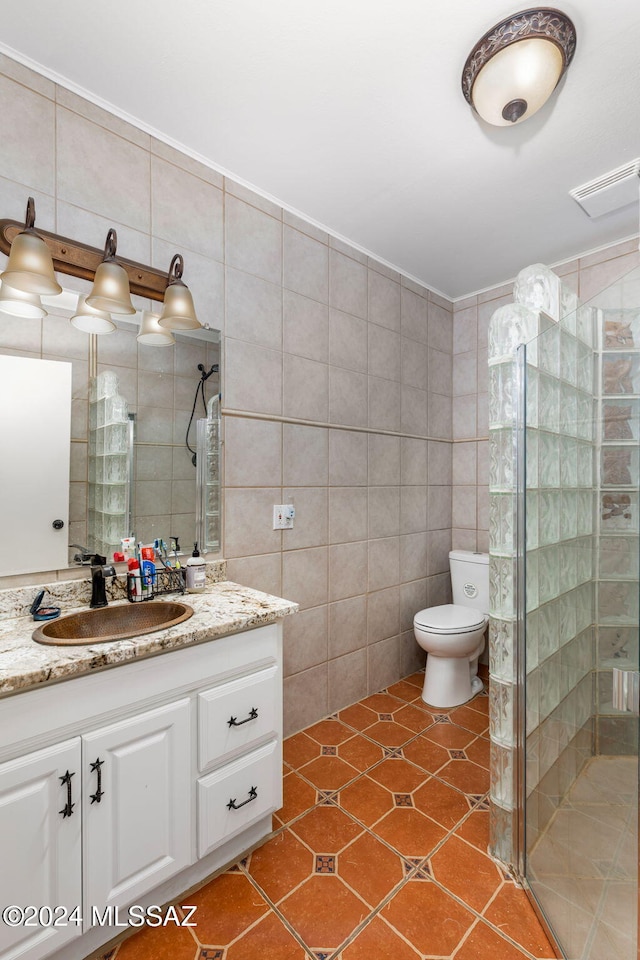 bathroom featuring tile walls, vanity, tile patterned floors, and a shower with shower door