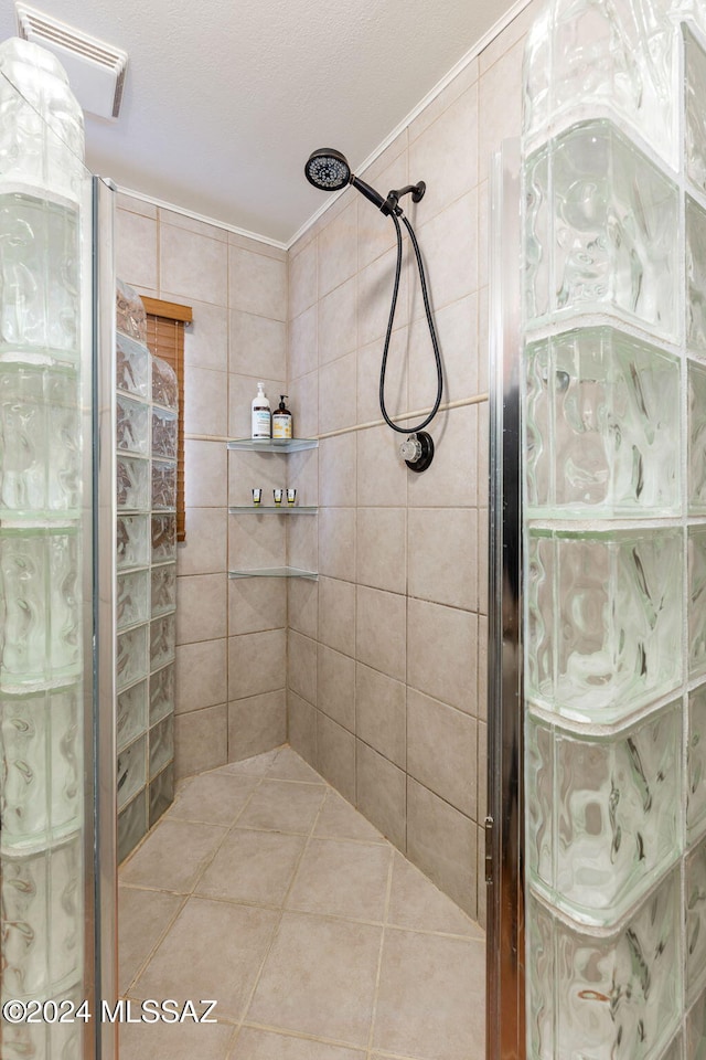 bathroom with tile patterned floors and a tile shower