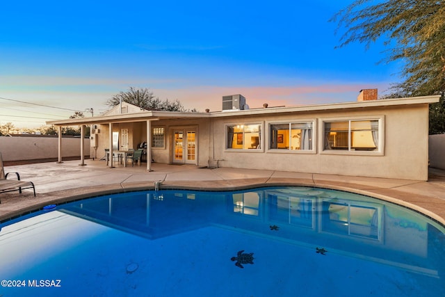 pool at dusk featuring a patio area