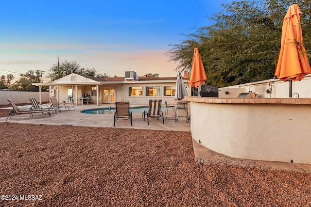 pool at dusk with a patio