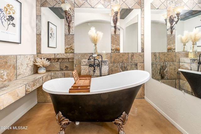 bathroom featuring concrete flooring and a tub to relax in