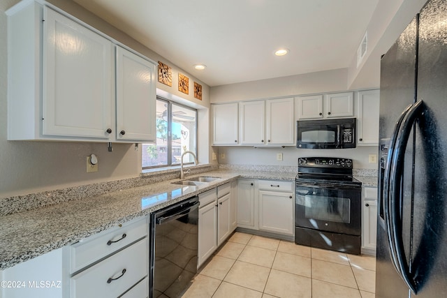 kitchen with light tile patterned flooring, sink, white cabinetry, and black appliances