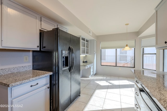 kitchen with black refrigerator with ice dispenser, light stone counters, white cabinets, hanging light fixtures, and light tile patterned flooring