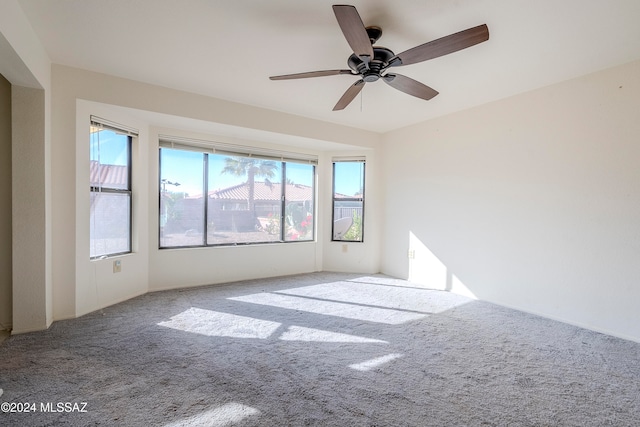 spare room with ceiling fan and light carpet