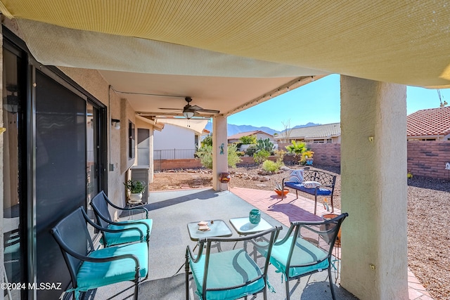 view of patio featuring ceiling fan and a mountain view