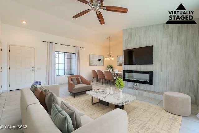 living room featuring light tile patterned floors, ceiling fan with notable chandelier, and a tiled fireplace