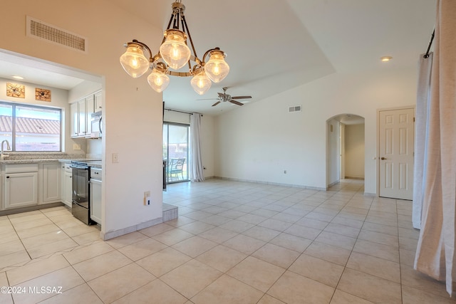 kitchen featuring white cabinets, a healthy amount of sunlight, ceiling fan with notable chandelier, and black range