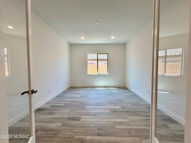 unfurnished bedroom with baseboards, recessed lighting, and wood finished floors