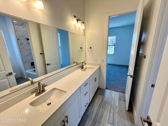 bathroom featuring double vanity, a sink, and wood finished floors