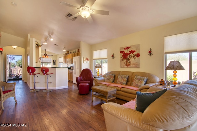 living room with dark hardwood / wood-style floors, ceiling fan, and vaulted ceiling