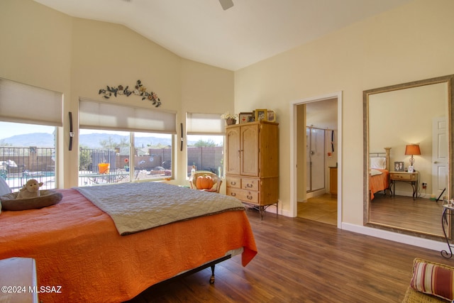 bedroom featuring ceiling fan, ensuite bathroom, a mountain view, wood-type flooring, and vaulted ceiling