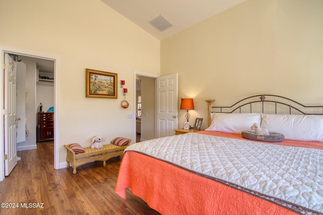 bedroom with dark hardwood / wood-style flooring and high vaulted ceiling