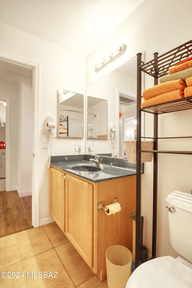 bathroom with toilet, vanity, washer / clothes dryer, and tile patterned floors