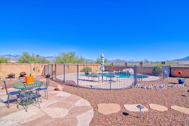 view of swimming pool with a mountain view and a patio area