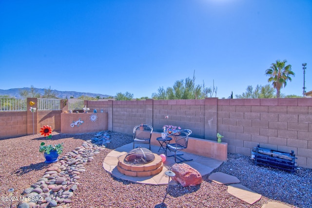 view of yard featuring a patio area, a mountain view, and a fire pit